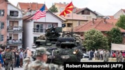 U.S. soldiers arrive on a tank during the presentation of their vehicles and weapons in Kumanovo on July 28, 2017.