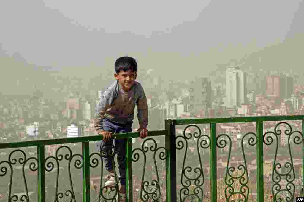 Хлопчык гуляе на вуліцы падчас моцнай пясчанай буры ў сталіцы Ірану Тэгеране.