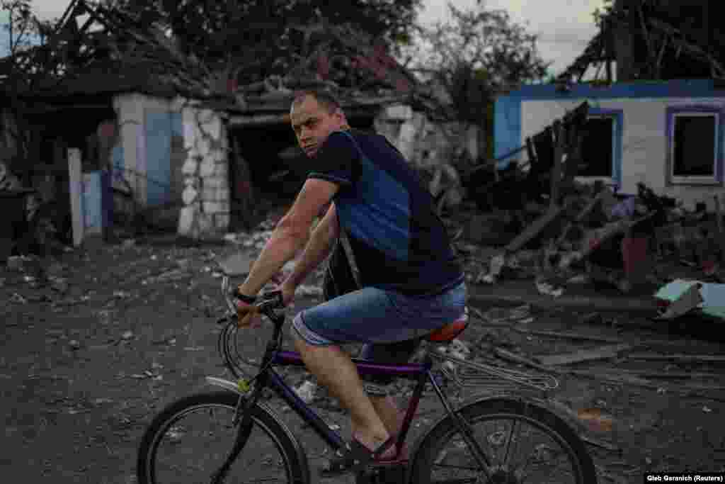 Чоловік проїжджає повз зруйновані російським ракетним ударом будинки у Добропіллі. Донецька область. 14 червня 2022 року. 14 червня Міністерство оборони Росії заявило, що за попередні 24 години вразило понад 100 цілей, включаючи скупчення військ і військову техніку України. В умовах війни цю заяву немає можливості належно перевірити