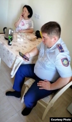 Замначальника управления внутренней политики акимата Акмарал Сабит и замначальника управления полиции Есильского района Марат Дубаев в квартире, в которой остановились безработные жанаозенцы. Нур-Султан, 24 июня 2022 года