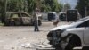 A man walks past a barricade made with destroyed police cars in the besieged Ukrainian city of Lysychansk. 
