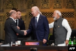 Президент США Джо Байден, президент Франции Эммануэль Макро, канцлер Германии Олаф Шольц и премьер-министр Индии Нарендра Моди приветствуют друг друга во время первой рабочей сессии саммита лидеров G20 в Нуса-Дуа, на индонезийском курортном острове Бали. 15 ноября 2022 года