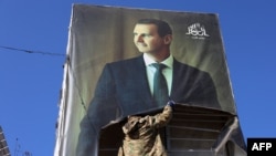 Алеппо шаарында бийликке каршы чыккан козголоңчу президент Башар Асаддын сүрөтүн сыйрып жатат. 30-ноябрь, 2024-жыл. 