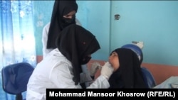 داکتر لطیفه نذیری در حال تداوی دندان های یکی از زنان ولایت غور 