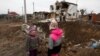 Children stand next to a crater left by a Russian military strike in the town of Hlevakha, outside Kyiv, on January 26.