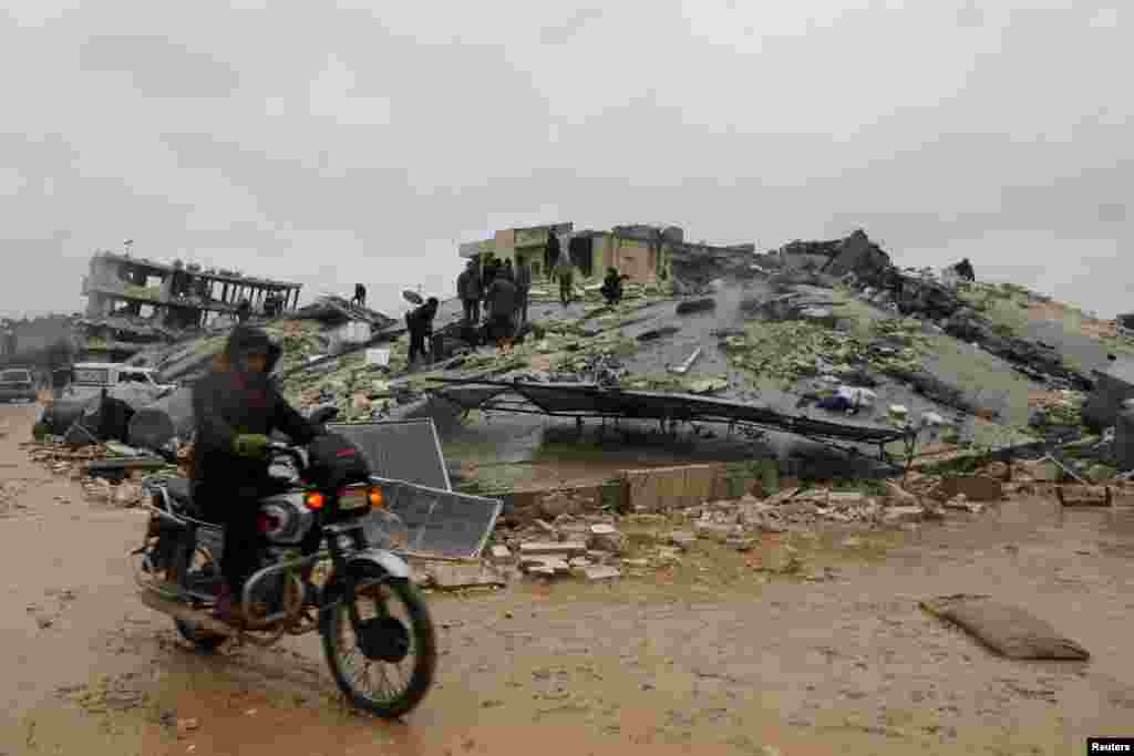 На фото: спасатели ищут выживших под завалами после землетрясения в удерживаемом повстанцами городе Джандарис, Сирия, 6 февраля 2023 года