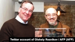 Німецький міністр оборони Борис Пісторіус з мініатюрною копією Leopard 2 позує з українським колегою Олексієм Резніковим, Київ, 7 лютого 2023 року