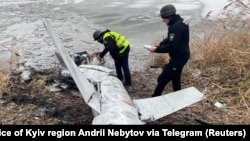 Украинские полицейские осматривают сбитую российскую крылатую ракету. Киевская область, январь 2023 года