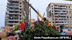 Люди приносять квіти та іграшки до місця ракетного удару по Дніпру. 17 січня 2023 року