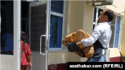 Сотрудник доставляет хлеб в госмагазин (Архивное фото)