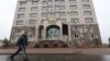 A man walks in Almaty, Kazakstan, walks past the office building of the Nur Otan ruling party, which was damaged during mass protests triggered by a fuel price increase in January. 