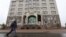 A man walks in Almaty, Kazakstan, walks past the office building of the Nur Otan ruling party, which was damaged during mass protests triggered by a fuel price increase in January. 