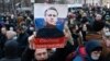 Supporters hold up a poster of jailed Russian opposition politician Aleksei Navalny, who said Russia's war with Ukraine will "destroy futures."