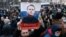 Supporters hold up a poster of jailed Russian opposition politician Aleksei Navalny, who said Russia's war with Ukraine will "destroy futures."