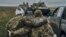A Ukrainian soldier helps a wounded comrade on a road in recently liberated territory in the Kharkiv region on September 12.
