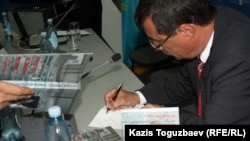 Евгений Жовтис пишет дарственную надпись на внутренней стороне обложки своей книги «Записки колониста поселенца и другие статьи и письма из неволи». Алматы, 16 апреля 2012 года