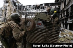 «Кіборги» під обстрілом забирають тіло танкіста (фото Сергія Лойка)