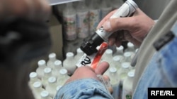 Львов шаарындагы дүкөндүн жумушчусу товарга орус энбелгисин коюуда. 