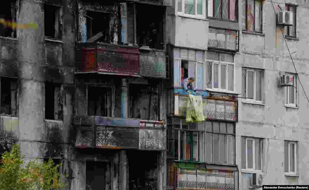 Жінка розвішує білизну, Маріуполь, 29 жовтня 2022 року. На початку війни Маріуполь майже 80 днів перебував в облозі армії РФ, під постійними обстрілами