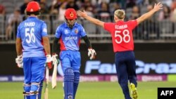 تصویر از تازه ترین رقابت میان تیم های انگلستان و افغانستان. سام کوران بازیکن تیم انگلستان پیروزی تیم خود را در برابر دو تن از اعضای تیم ملی کریکت افغانستان فریاد می زند. 