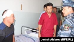 Министр внутренних дел Кыргызстана Кашкар Джунушалиев (справа) навестил пострадавших во время конфликта. Баткен. 23 июля 2019 года.