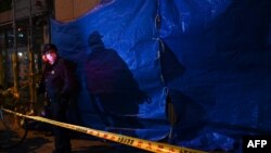 Осакадагы өрт тутанган психиатриялык клиниканын жанында турган офицер. 17-декабрь, 2021-жыл.  