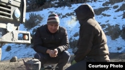 Токтосун Шамбетов Кара-Кечеде кезек күткөн айдоочу менен.