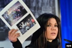 Украинская певица Руслана держит фотографии украинских протестов на пресс-конференции в Берлине. 1 февраля 2014 года.