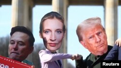 Активисти носят маски с лицата на бизнесмена Илон Мъск, лидерката на "Алтернатива за Германия" Алис Вайдел и президента на САЩ Доналд Тръмп по време на протест в Берлин