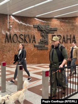 Пластика «Прага-Москва» на задньому плані фото з перехожими на станції метро «Ангел» (чеською «Андєл»), Прага, Чехія, 30 вересня 2025 року