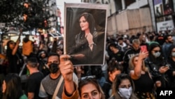 Махса Амининин сүрөтүн кармаган демонстранттар. Иран.