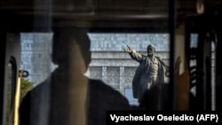 Наразылардың бірі Ленин ескерткішіне қарап тұр.