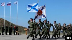 Орусиянын коргоо министри Сергей Шойгу (арткы катарда солдон үчүнчү) Севастополдогу аскер-деңиз флотуна Орусиянын желегин илүү салтанатына катышууда. 24-март, 2014-жыл