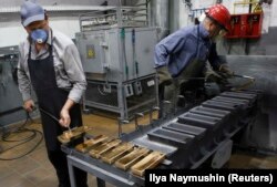 Рабочие обрабатывают слитки золота чистотой 99,99 процента на заводе цветных металлов «Красцветмет», одном из крупнейших в мире производителей драгоценных металлов, в сибирском городе Красноярске