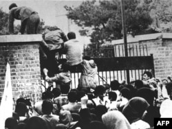 Іранскія студэнты пералазяць агароджу пасольства ЗША ў Тэгеране, 4 лістапада 1979 году