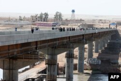 Ооган-тажик чек арасынан Төмөнкү Пянж көпүрөсү аркылуу өтүп жаткан кишилер. 26-август 2007-жыл.