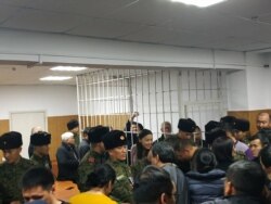 Сапар Исаков темир тордун ичинен кол булгалап жатат. 6-декабрь, 2019-жыл.