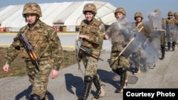 Kosovo - Armenian soldiers walk in riot gear to a U.S. Black Hawk helicopter during a training exercise at Camp Bondsteel, March 12, 2014. (Photo courtesy of www.army.mil)