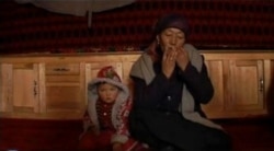 Тарбагатайлык кыргыз аял темир комуз кагууда.