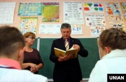 Тодішній міністерський комісар з питань управління транскордонними інвестиціями Управління прем'єр-міністра Угорщини Іштван Ґрежа розглядає підручник з угорської мови під час візиту на Закарпаття, в одному з класів початкової школи з поглибленим вивченням угорської мови. Закарпатська область, Свалява, 5 листопада 2015 року