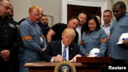 Президент Дональд Трамп болот менен алюминийге бажы салыгын киргизүү чечимине кол коюп жатат. Вашингтон, 8-март, 2018-жыл.