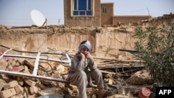 یک بازمانده زلزله در افغانستان بر روی بقایای یک خانه ویران‌شده در یکی از روستاهای تاشقرغان، در ولسوالی خُلمِ ولایت سمنگان نشسته است. ۳ نوامبر ۲۰۲۵