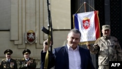 Ukraine -- Russian acting leader of Crimea Sergei Aksyonov holds a Kalashnikov during the celebration of Defender of the Fatherland Day in the Crimean city of Simferopol, February 23, 2015