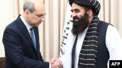 Ресейдің Кабулдағы елшісі Дмитрий Жирнов (сол жақта) Ауғанстан сыртқы істер министрінің міндетін атқарушы Әмір Хан Муттакиге Ресей үкіметі Ауғанстан Ислам Әмірлігін ресми түрде мойындайтыны туралы Мәскеудің шешімін табыс етіп тұр. Кабул, 3 шілде, 2025 жыл.