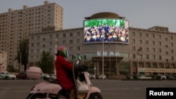 Hotan şäherindäki köçäniň çatrygynda goýlan ekran Hytaýyň prezidenti Si Jinpini görkezýär. 2021-nji ýylyň 30-njy apreli.