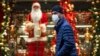 A man wearing a face mask walks in front of a shop window decorated for Christmas and New Year celebrations in Moscow. (illustrative photo)