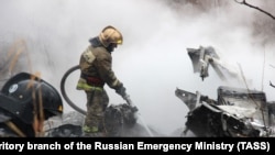 RUSSIA -- A firefighter works at the site of a helicopter crash in Khabarovsk, April 11, 2018