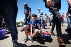 Люди в очереди на линии соприкосновения в Донбассе. Маски есть не у всех. 10 мая