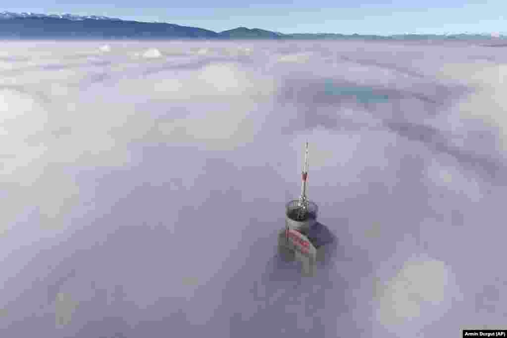 Босния-Герцеговина, Сараево. 172 метр бийиктиктеги Avaz Twist Tower мунарасы туман жана ыштын фонунда.&nbsp;&nbsp;