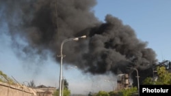 Armenia -- Onlookers watch as black smoke billows from the Nairit chemical plant in Yerevan hit by an explosion on 14May2009